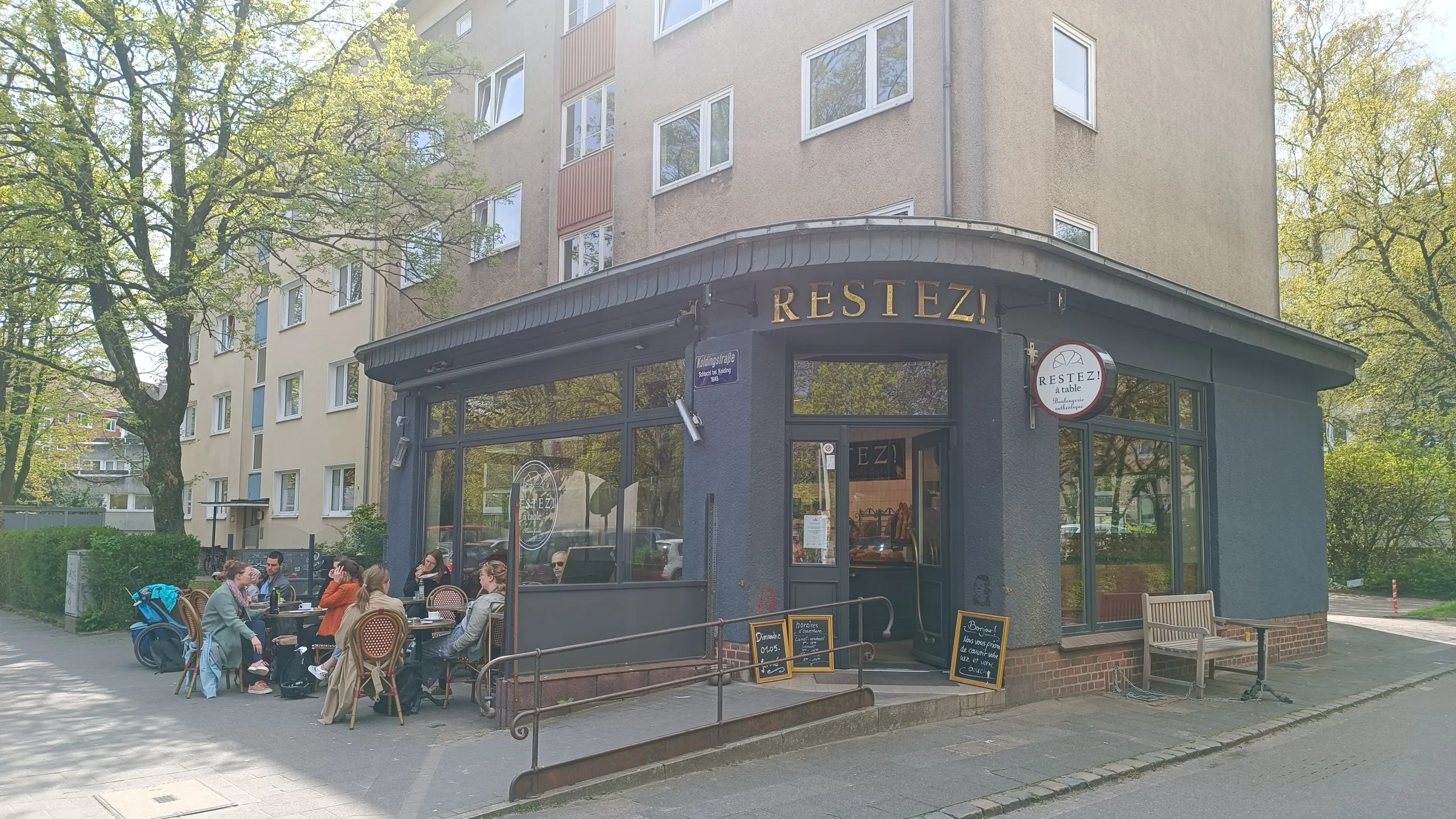 Die Ecke Koldingstraße mit Außenplätzen unter Bäumen
