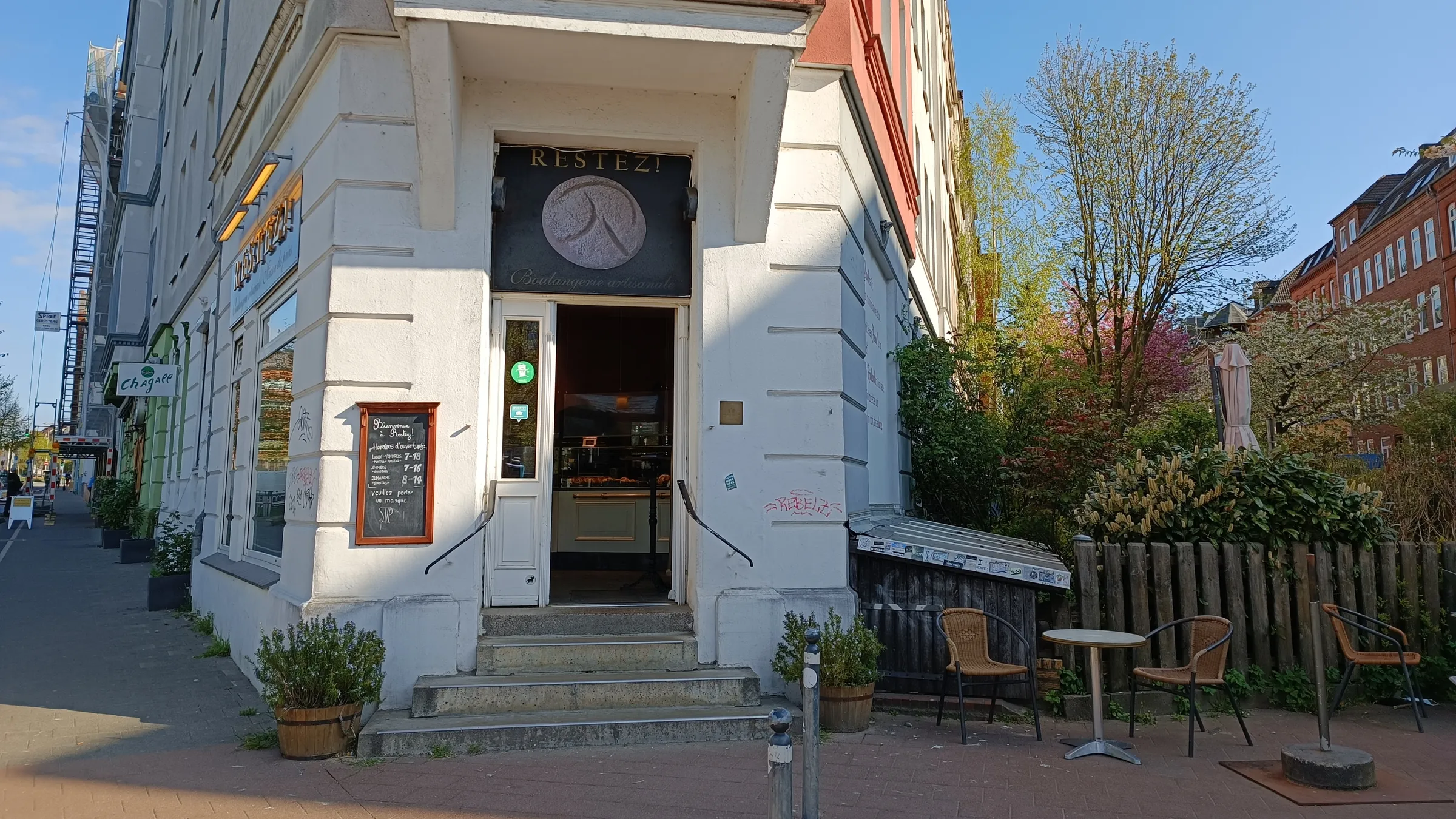 Eckeingang in der Sternstraße mit Uhrenschild und Außenplätzen