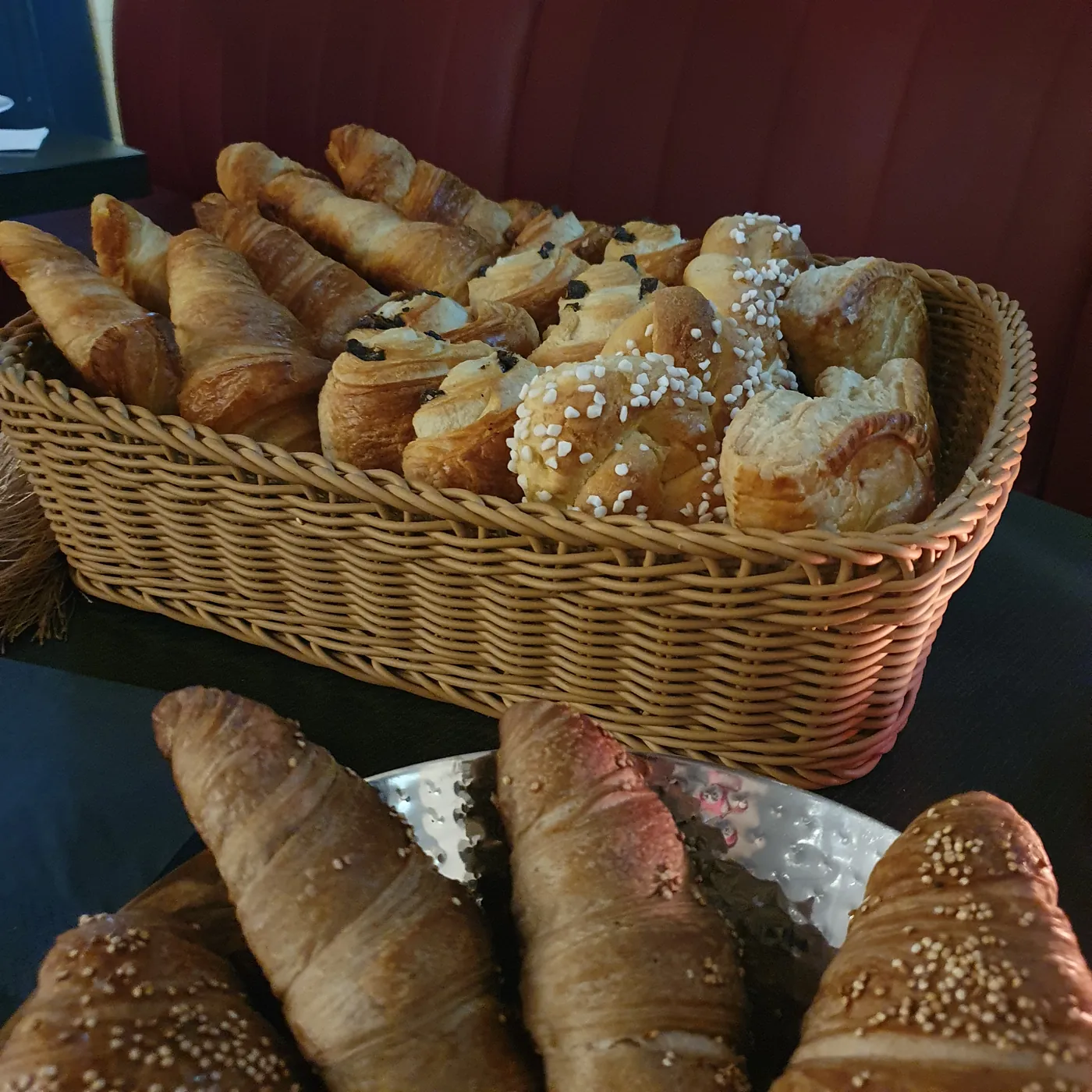 Korb mit Croissants und Brioches, davor Croissants auf einer Schale